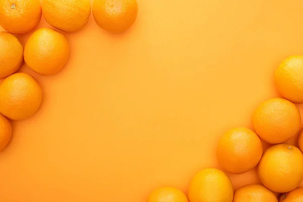 Vue de dessus des oranges entières juteuses mûres sur fond coloré avec espace de copie — Photo de stock