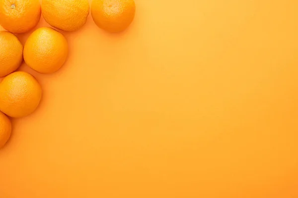 Vue de dessus des oranges entières juteuses mûres sur fond coloré avec espace de copie — Photo de stock