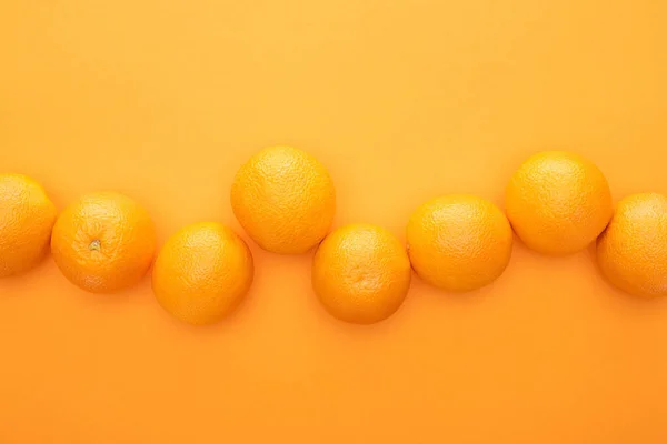 Vue de dessus des oranges entières juteuses mûres sur fond coloré avec espace de copie — Photo de stock