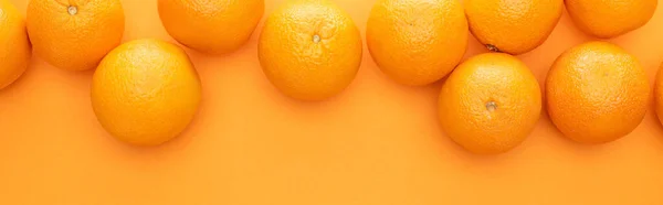 Top view of ripe juicy whole oranges on colorful background with copy space, panoramic shot — Stock Photo