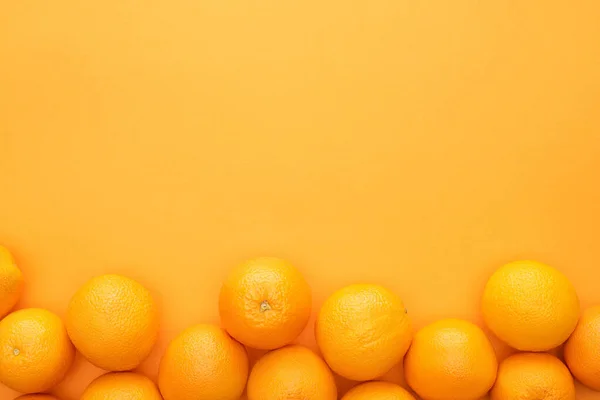 Draufsicht auf reife saftige ganze Orangen auf buntem Hintergrund mit Kopierraum — Stockfoto