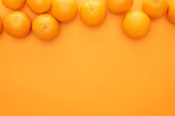 Draufsicht auf reife saftige ganze Orangen auf buntem Hintergrund mit Kopierraum — Stockfoto