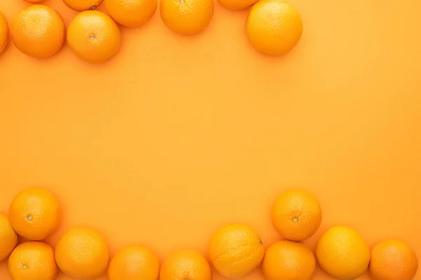 Vista superior de naranjas enteras jugosas maduras sobre fondo colorido - foto de stock