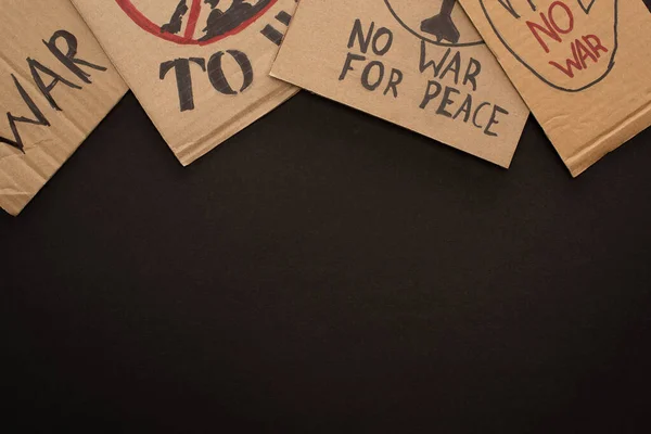 Vista superior de cartazes de papelão sem letras de guerra no fundo preto — Fotografia de Stock