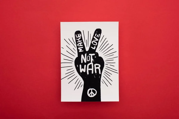 Top view of drawing with make love not war lettering and peace sign on red background — Stock Photo