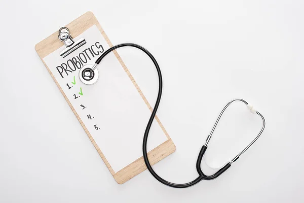 Top view of clipboard with probiotics empty list and stethoscope on white background — Stock Photo