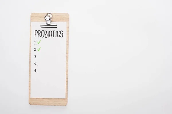 Top view of clipboard with probiotics empty list on white background — Stock Photo