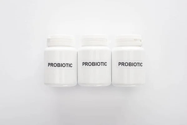 Vista superior de recipientes com letras probióticas sobre fundo branco — Fotografia de Stock