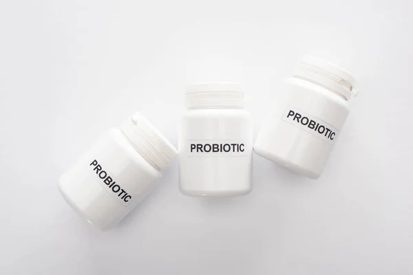 Vue de dessus des récipients avec lettrage probiotique sur fond blanc — Photo de stock