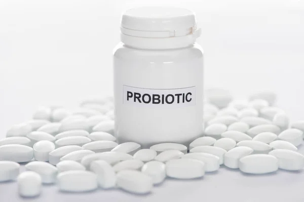 Selective focus of probiotic container near pills on white background — Stock Photo