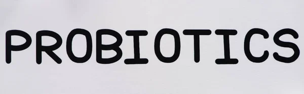 Vista superior de papel com letras probióticos e pílulas sobre fundo branco, orientação panorâmica — Fotografia de Stock
