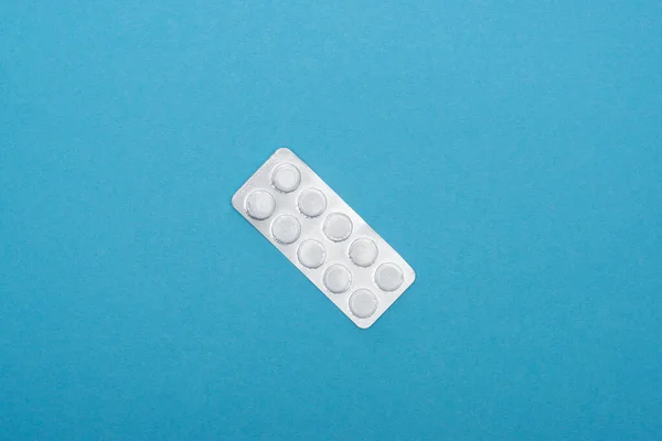 Top view of pills in blister pack on blue background — Stock Photo