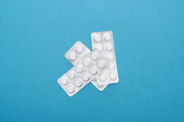 Top view of pills in blister packs on blue background — Stock Photo