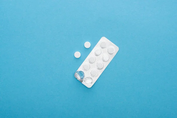 Top view of pills in blister pack on blue background — Stock Photo