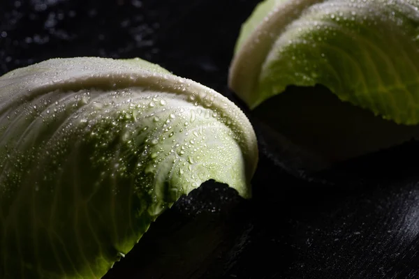 Close up view of wet green cabbage leaves on black — Stock Photo