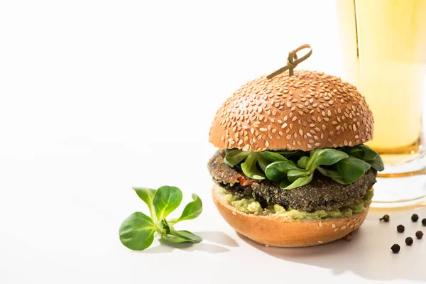 Delicioso hambúrguer vegan verde com microgreens, óleo, pimenta preta no fundo branco — Fotografia de Stock