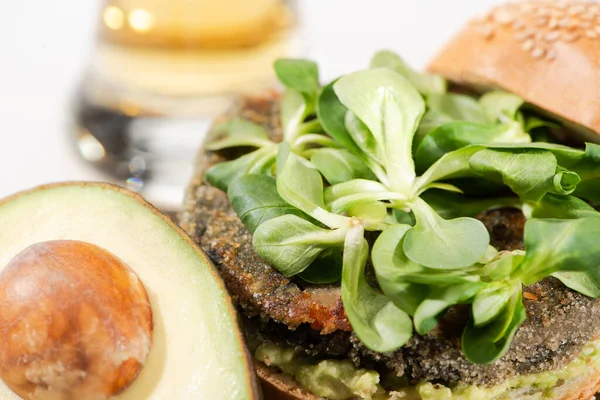 Vista de cerca de deliciosa hamburguesa verde vegana con microgreens, aguacate - foto de stock