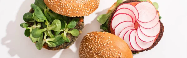 Top view of vegan burgers with microgreens, radish on white background, panoramic shot — Stock Photo