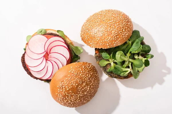 Top view of vegan burgers with microgreens, radish on white background — Stock Photo