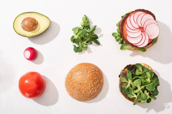 Vista dall'alto di hamburger vegani con ingredienti vegetali su sfondo bianco — Foto stock