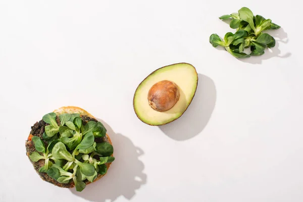 Top view of vegan burger with avocado and microgreens on white background — Stock Photo