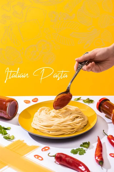 Vue recadrée d'une femme ajoutant du ketchup aux spaghettis sur une surface blanche isolée sur une illustration jaune de pâtes italiennes — Photo de stock