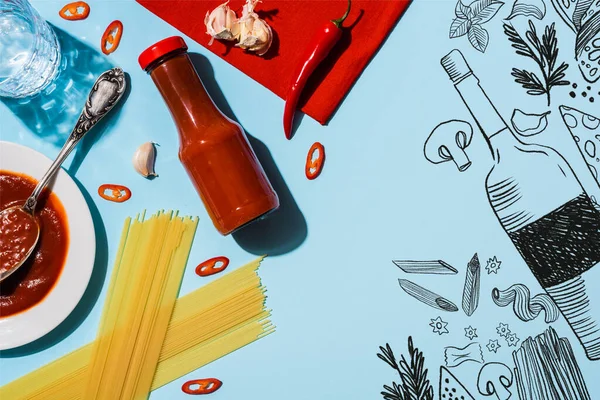Vista dall'alto del ketchup piccante con aglio e peperoncino accanto agli spaghetti su sfondo blu, illustrazione alimentare — Foto stock