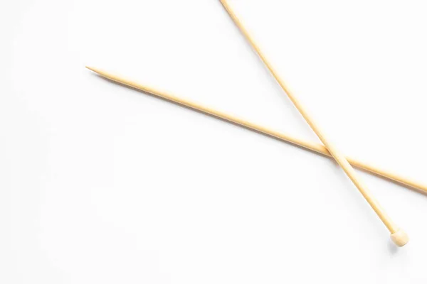 Beige knitting needles on white background with copy space — Stock Photo