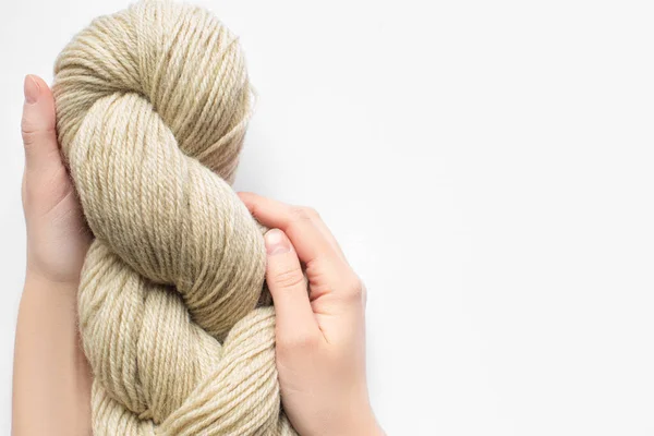 Cropped view of woman holding beige yarn on white background with copy space — Stock Photo