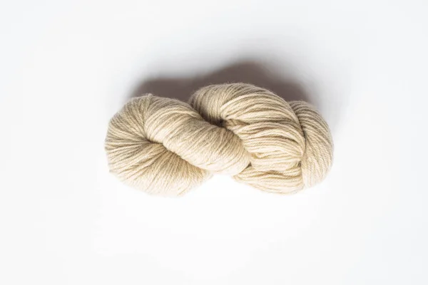 Top view of beige yarn on white background with copy space — Stock Photo