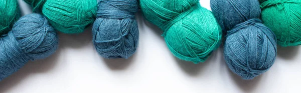 Vista dall'alto del filato di lana blu e verde su sfondo bianco, orientamento panoramico — Foto stock