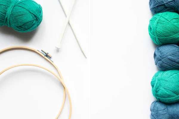 Top view of blue and green wool yarn, knitting looms and knitting needles on white background — Stock Photo