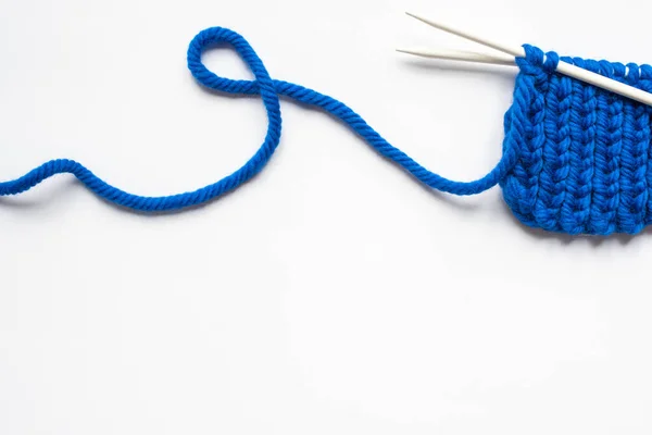 Top view of blue wool yarn and knitting needles on white background — Stock Photo