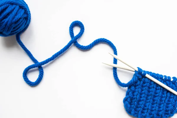 Vista superior de fios de lã azul e agulhas de tricô no fundo branco — Fotografia de Stock