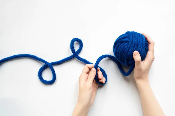 Vista cortada da mulher segurando de fios de lã azul e agulhas de tricô no fundo branco — Fotografia de Stock