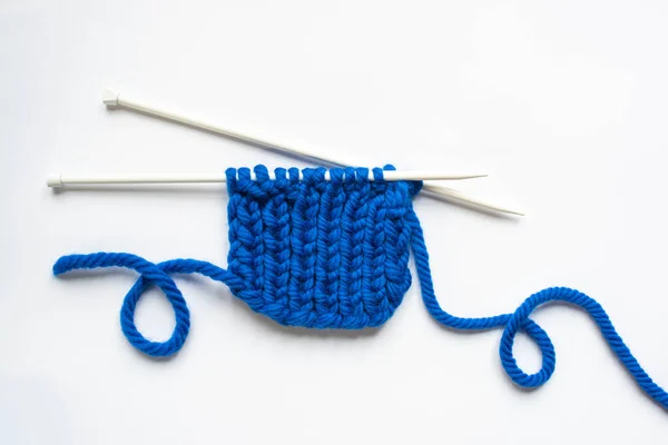 Vue du dessus des fils de laine bleue et des aiguilles à tricoter sur fond blanc — Photo de stock