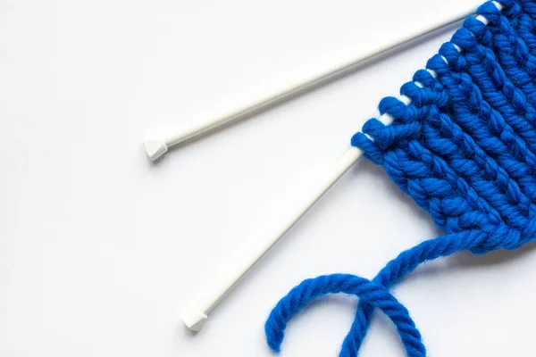 Top view of blue wool yarn and knitting needles on white background — Stock Photo