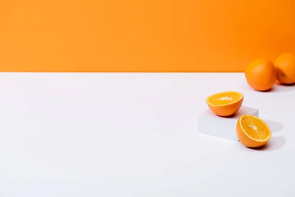 Fresh ripe oranges on white surface isolated on orange — Stock Photo