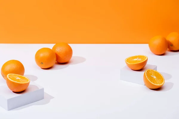 Oranges mûres fraîches sur surface blanche isolées sur orange — Photo de stock