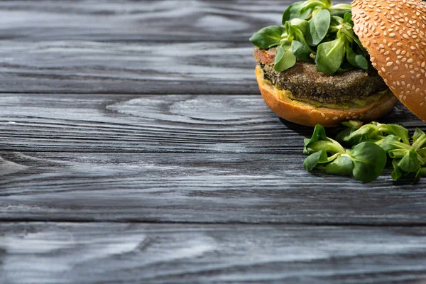 Hambúrguer vegan saboroso com microgreens servidos na mesa de madeira — Fotografia de Stock