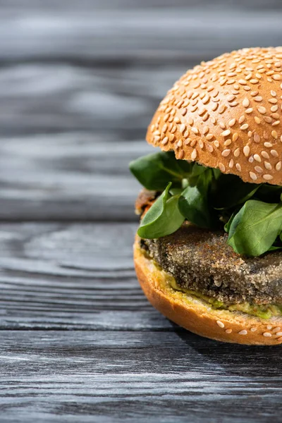 Tasty vegan burger with microgreens served on wooden table — Stock Photo