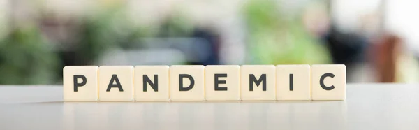 Horizontal image of white cubes with pandemic lettering on white desk, covid-19 concept — Stock Photo