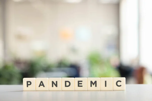 Weiße Würfel mit pandemischem Schriftzug auf weißem Schreibtisch, Covid-19-Konzept — Stockfoto