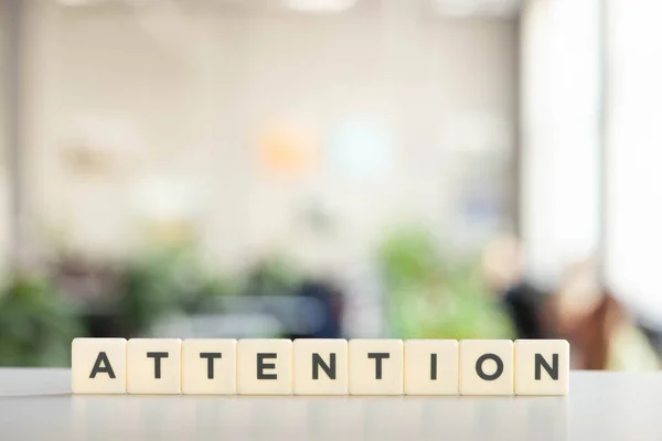 White cubes with attention lettering on white desk — Stock Photo