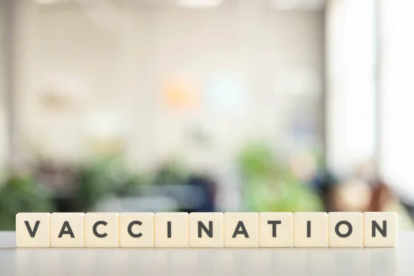 White cubes with vaccination lettering on white desk, covid-19 concept — Stock Photo