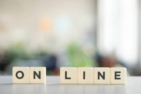 Bloques blancos con letras en línea en el escritorio blanco - foto de stock