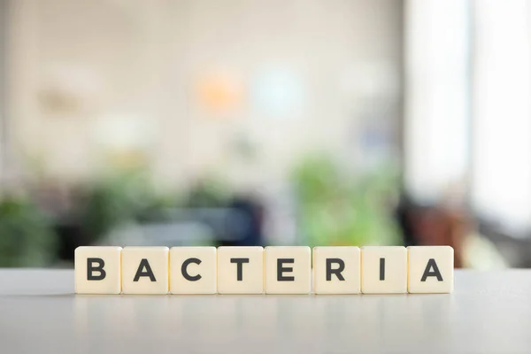 White cubes with bacteria word on white surface, covid-19 concept — Stock Photo