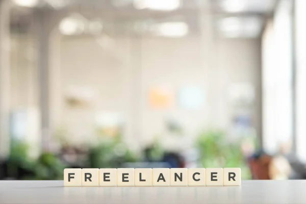 White cubes with freelancer lettering on white desk — Stock Photo