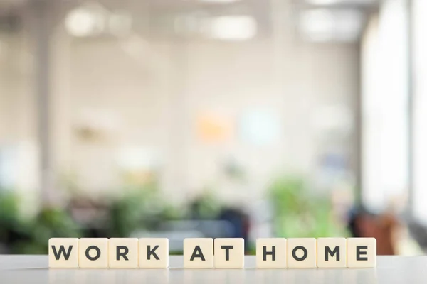 White cubes with work at home lettering on white desk in office — Stock Photo