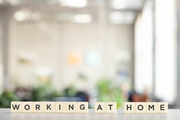 White cubes with working at home lettering on white desk — Stock Photo